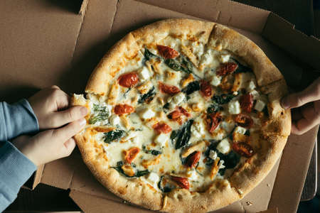 Hands taking pieces of pizza. Top view.の写真素材