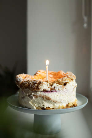 Polish Carpathian Mountain Cream Cake with birthdate candle on blue ceramic cake stand. Homemade karpatka.の写真素材