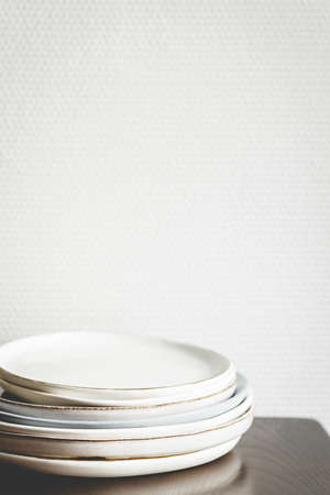Stack of ceramis plates against white wall.の写真素材