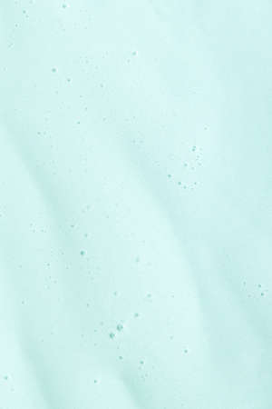 Hyaluronic acid serum texture with bubbles on turquoise background.の写真素材
