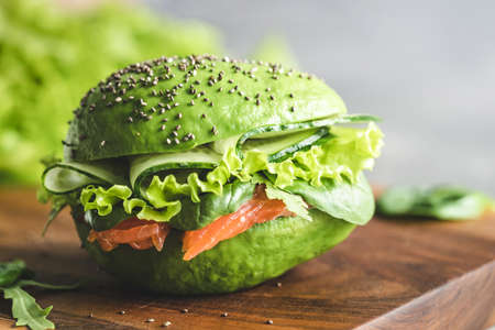 Avocado burger with salmon on wooden board.の写真素材