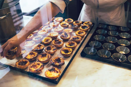 Traditional Portuguese dessert - Pastel de nata in baking processes.の写真素材