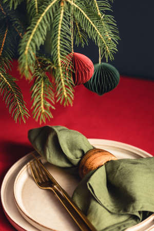 Christmas table setting decorated with spruce branches in deep color palette.の写真素材