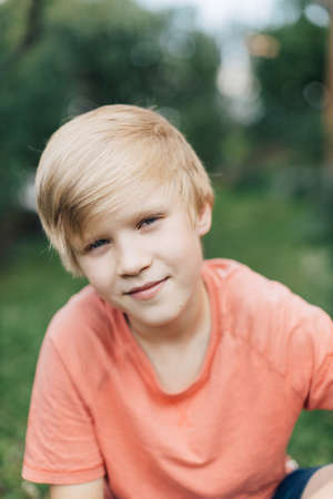 Smiling teenage boy looking at the camera outdoors.の写真素材