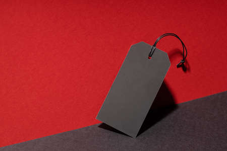 Blank black price tag on red and black background.の写真素材