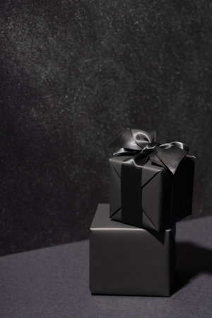 Stack of two black gift boxes on black background.の写真素材