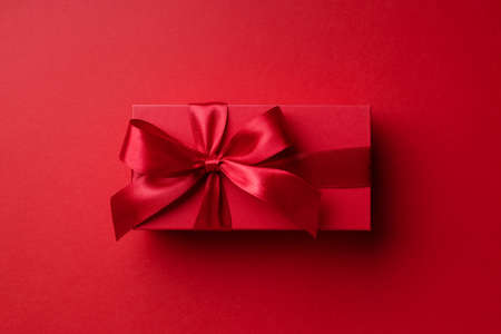 Top view on red gift box on red background for Christmas or Valentines day.の写真素材