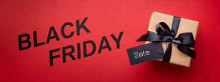 Black Friday banner with gift box and price tag on red background.の写真素材