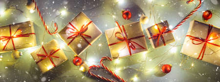 Banner with white Christmas gift boxes with garland lights and snow.