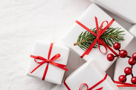 Closeup of Christmas gift boxes on white tablecloth.