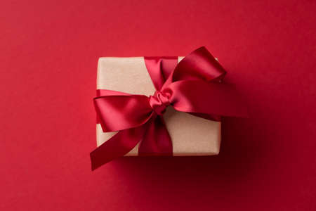 Close up of gift box tied red ribbon on red background.の写真素材