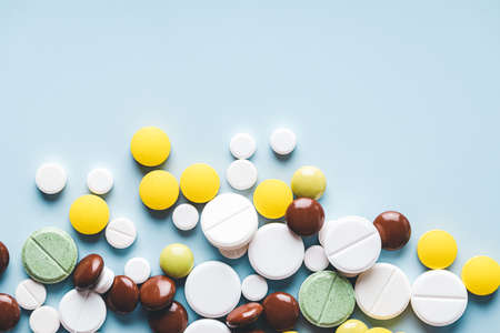 Various pills on blue background with copy space.の写真素材