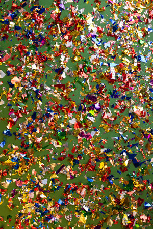 Bright Christmas or party card with colorful confetti on green background.の写真素材