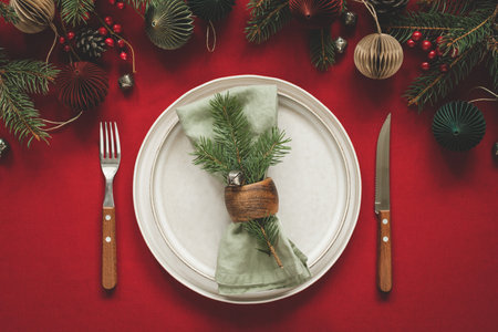 Christmas table setting on red tablecloth with New Year decorations.の写真素材