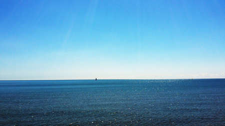 Flat calm Sea and blue skyの写真素材