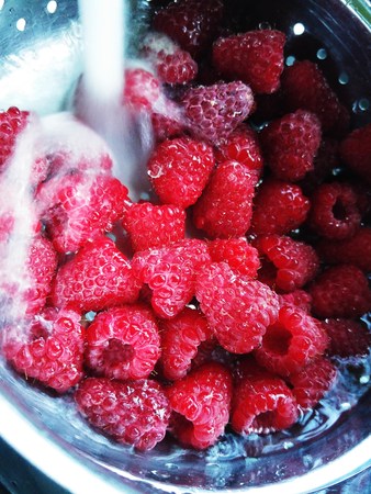 Washing fresh raspberriesの写真素材