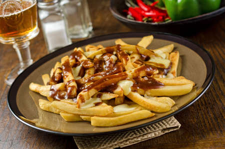 A plate of delicious poutine with french fries, gravy, and cheese curd 