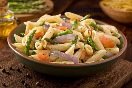 A delicious smoked salmon pasta with penne, asparagus, crushed black pepper, olive oil, and dill.の写真素材