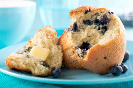 A delicious freshly baked blueberry muffin with melted butter.の写真素材