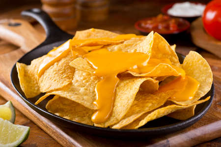 A plate of delicious plain nacho corn chips with cheese sauce.の写真素材