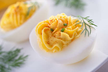 Delicious deviled eggs with paprika, chive, and dill garnish.