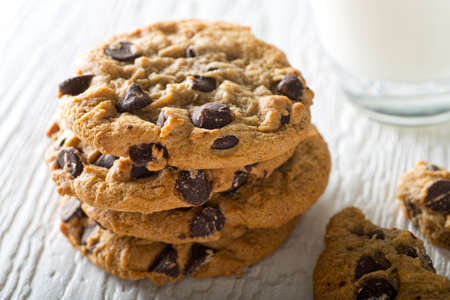 Delicious home baked chocolate chip cookies with a glass of milk.の写真素材