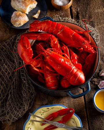 Lobsters in a pot on a rustic wooden table.の写真素材