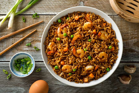 Delicious shrimp fried rice with egg, carrot, garlic, green peas and scallions.の写真素材