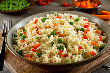 Delicious vegetable rice pilaf with green peas, carrots and red peppers.の写真素材
