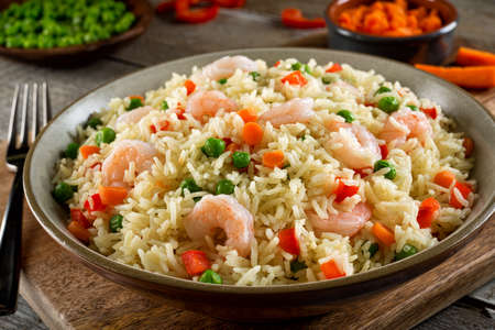 Delicious shrimp and vegatable rice pilaf with green peas, carrots and red peppers.の写真素材