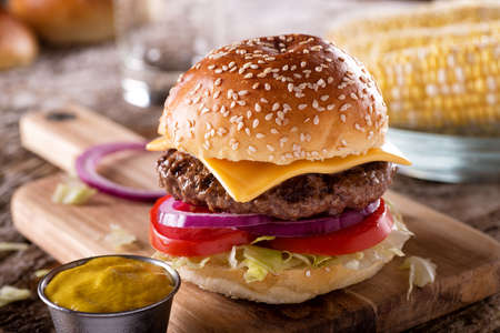 A delicious barbecue cheeseburger with lettuce, tomato and onions.の写真素材
