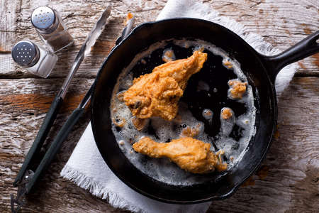 Delicious pan fried chicken in a cast iron frying pan.の写真素材
