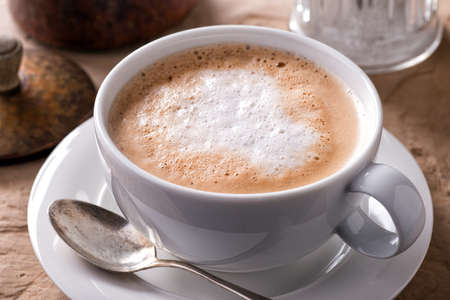 A cup of delicious hot and foamy cafe latte.の写真素材