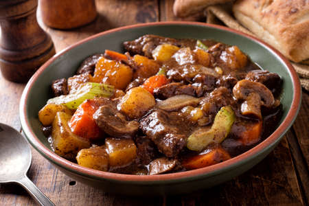 A bowl of delcious hearty homemade beef stew with potato, turnip, carrot, celery, mushroom and onion.の写真素材
