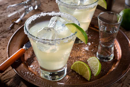 Delicious tequila and lime margaritas on a copper charger with coarse salt rimmer.の写真素材