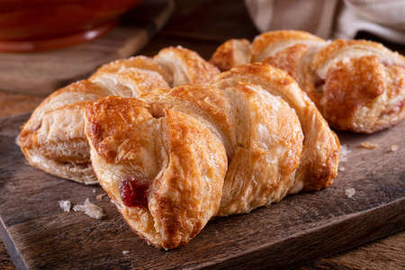 Delicious braided cherry mini strudels on a rustic wood counter top.の写真素材