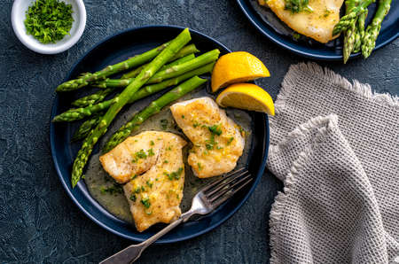 Delicious pan seared halibut with lemon butter sauce and asparagus.の写真素材