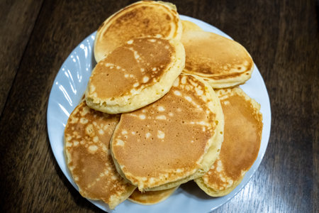 Plate of pancakes on kitchen table.の写真素材