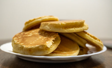 Plate of pancakes on kitchen table.の写真素材