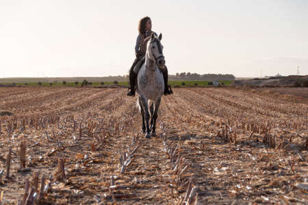 young woman with handkerchief on her neck on horsebackの写真素材
