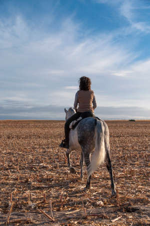 young woman with handkerchief on her neck on horsebackの写真素材