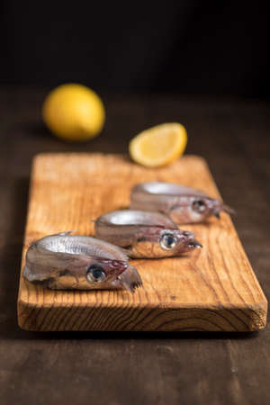 Blue whiting or lilies, fish on the table prepared to be cleaned and cooked in different ways,...