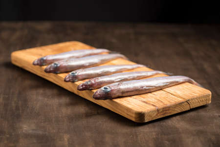 Blue whiting or lilies, fish on the table prepared to be cleaned and cooked in different ways,...