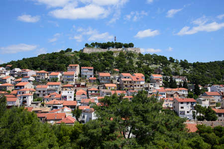 Sloping houses with the fortress at the top, in Sibenik, Croatia, Europe, situated next to the mouth of the river Krka on the Adriatic coastの写真素材