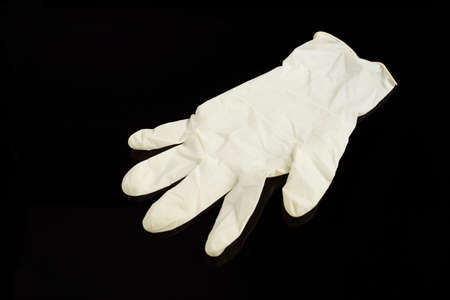 Beige latex gloves, on black background. Protector to prevent contagion.の写真素材