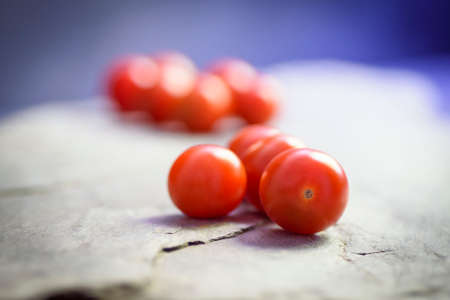 closeup and unfocused background of cherry tomatoes on a slate surfaceの写真素材