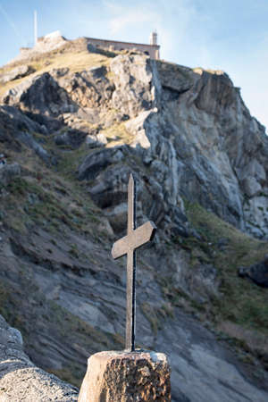 Iron cross of the hermitage of San Juan de Gaztelugatxe located on an islet in Bermeo, Biscay,...