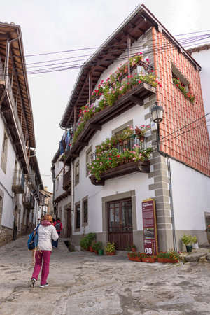 people walking through the narrow streets of Candelario, Salamanca, Castilla Leon, Spain, Europe. Facade full of flowers.のeditorial素材