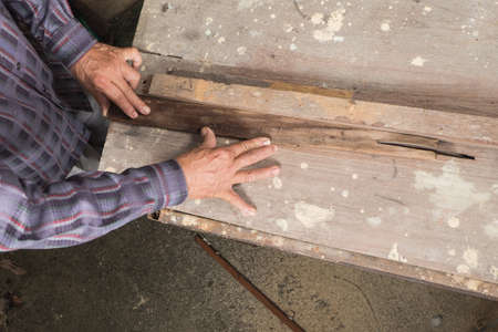 Asian carpenter Is sawing wood, Working hands with toolsの写真素材