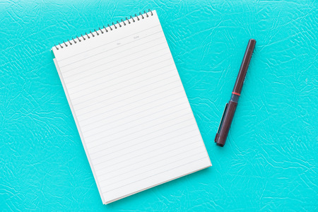 blank paper and pen with blue backgroundの写真素材